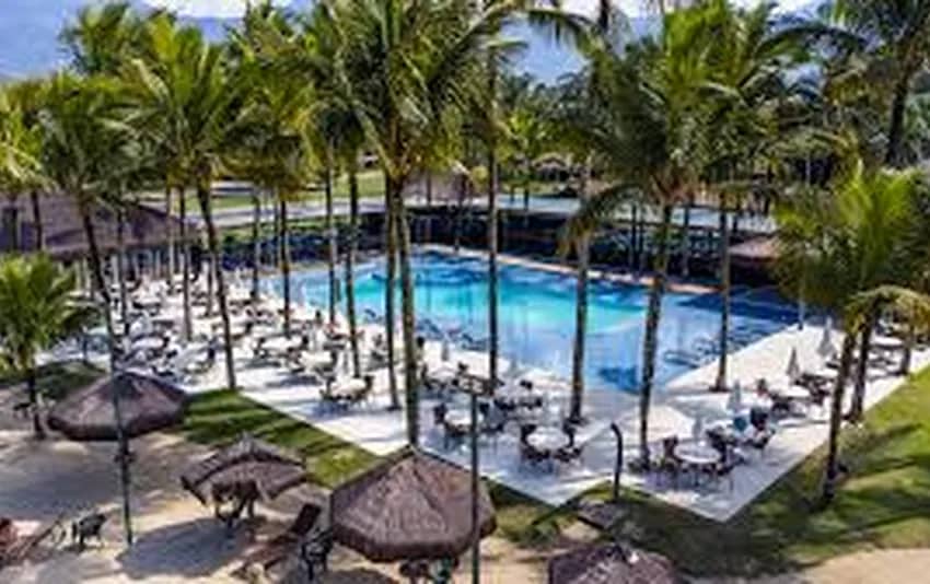 Foto piscina com coqueiros e quiosques em volta no Portobello Park Hotel