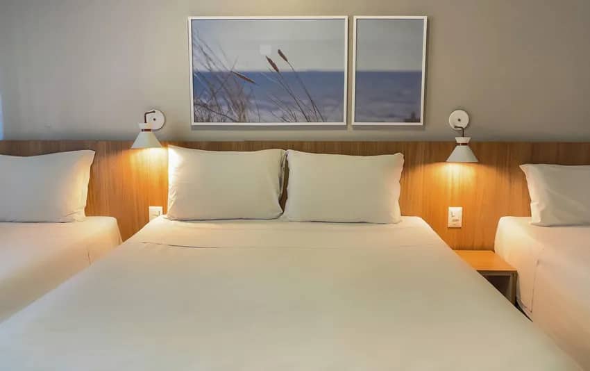Foto de um quarto com uma cama de casal centralizada e duas camas de solteiro nas laterais no Hotel Itália